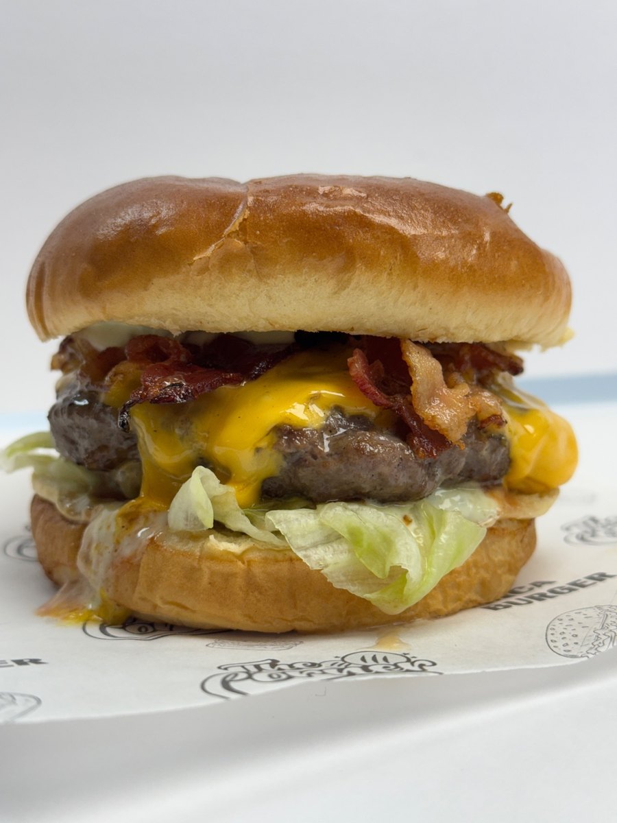 The Corner burger with melted cheese, bacon, lettuce, and sauce