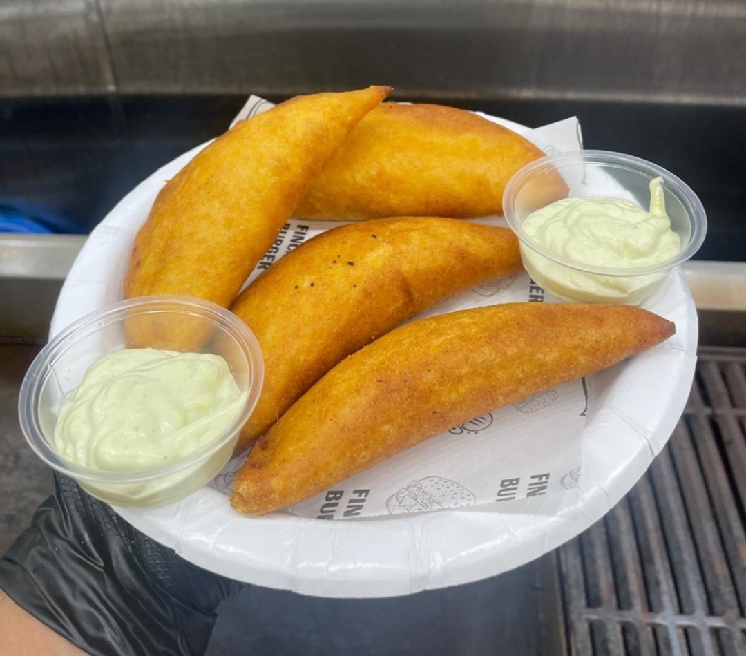 Plate of golden Venezuelan empanadas with sauce cups